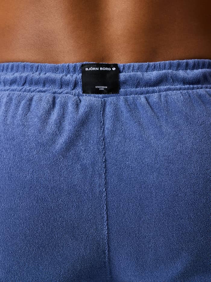 Achteraanzicht van de Borg Toweling Pool Shorts in Coastal Fjord (Blauw) van badstof met een zwart logolabel. - Image 2