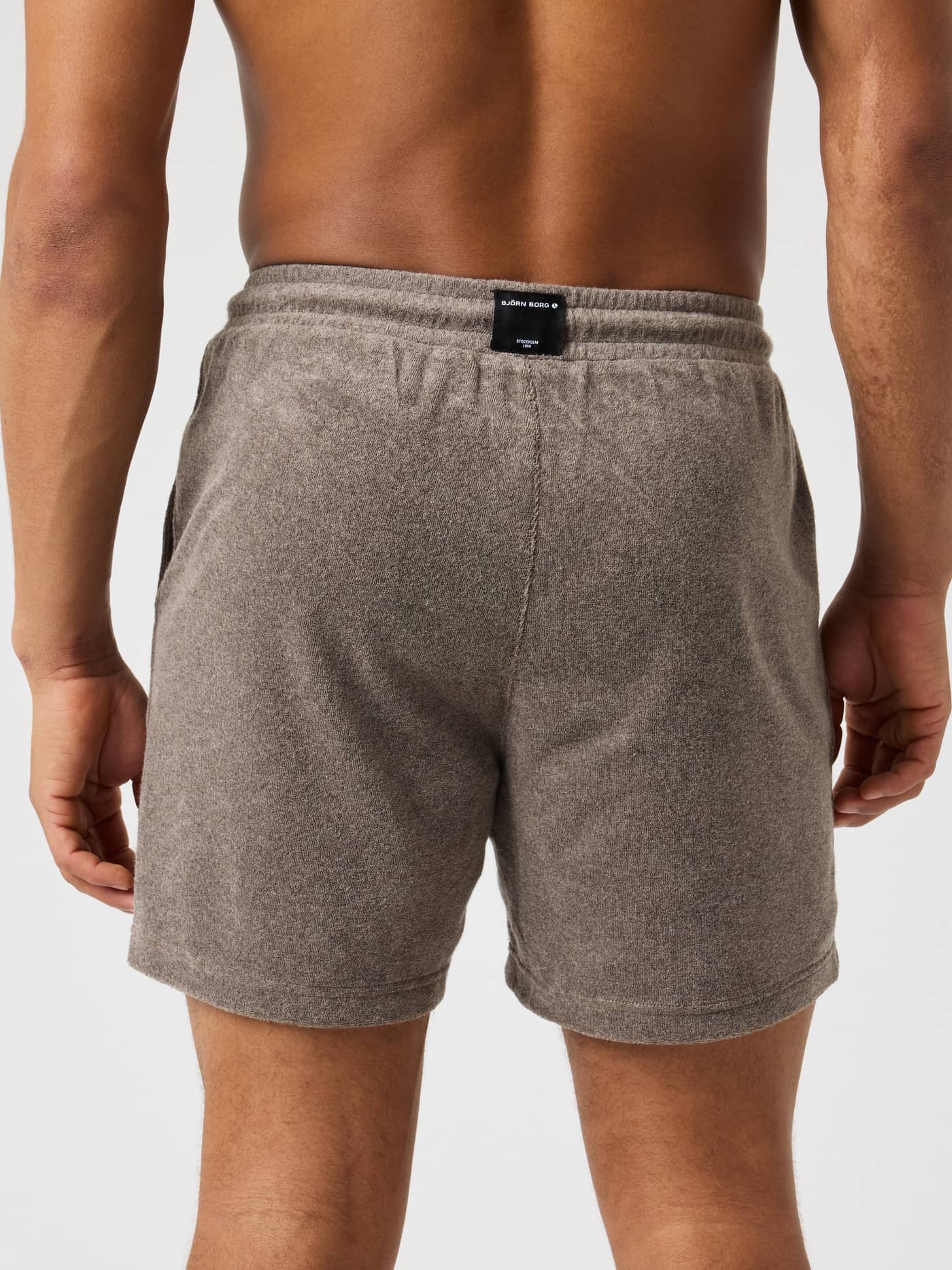 Achteraanzicht van een man in de Borg Toweling Pool Shorts in Taupe Melange (Beige) van stijlvolle badstof. - Image 2