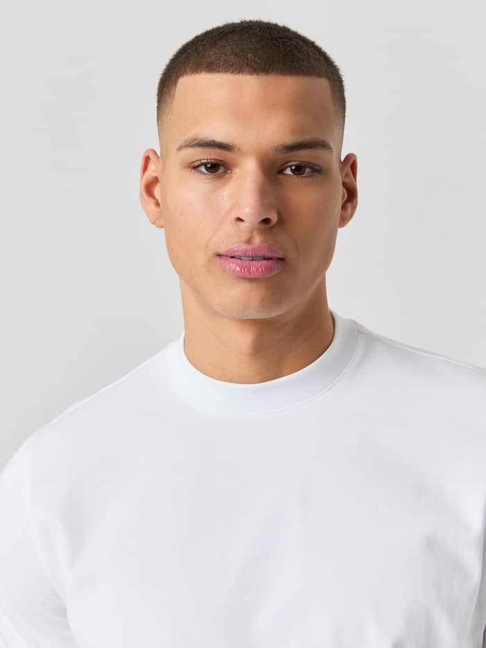 Close-up van een man in het Björn Borg Centre High Neck T-Shirt in Brilliant White (Wit) met een functionele mock neck. - Image 4