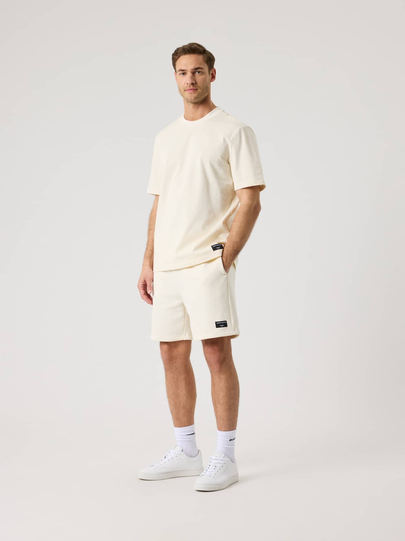 Ganzkörperansicht eines Mannes im Centre High Neck T-Shirt in Tofu (Weiß) aus 100 % Baumwolle mit lässigem, stylischem Fit. - Image 3