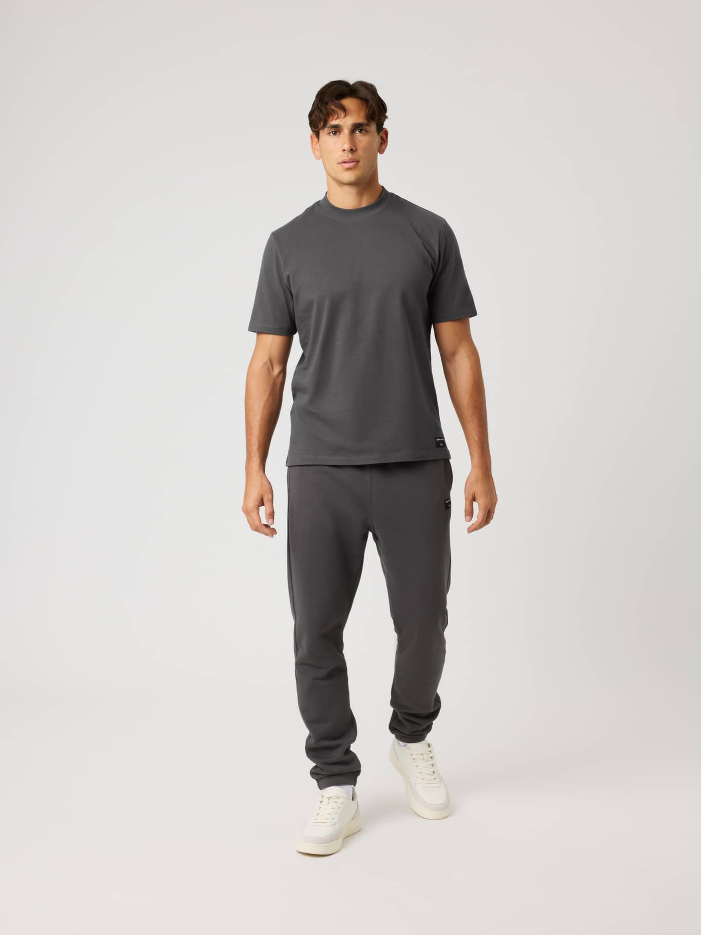 Full-body front view of the cotton Centre High Neck T-Shirt in Asphalt (Grey) with an oversized fit and black logo label. - Image 3