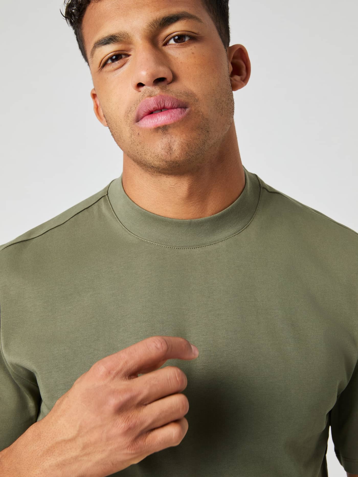 Detailed close-up of a man wearing the cotton Björn Borg Centre High Neck T-Shirt in Dusty Olive (Green). - Image 4