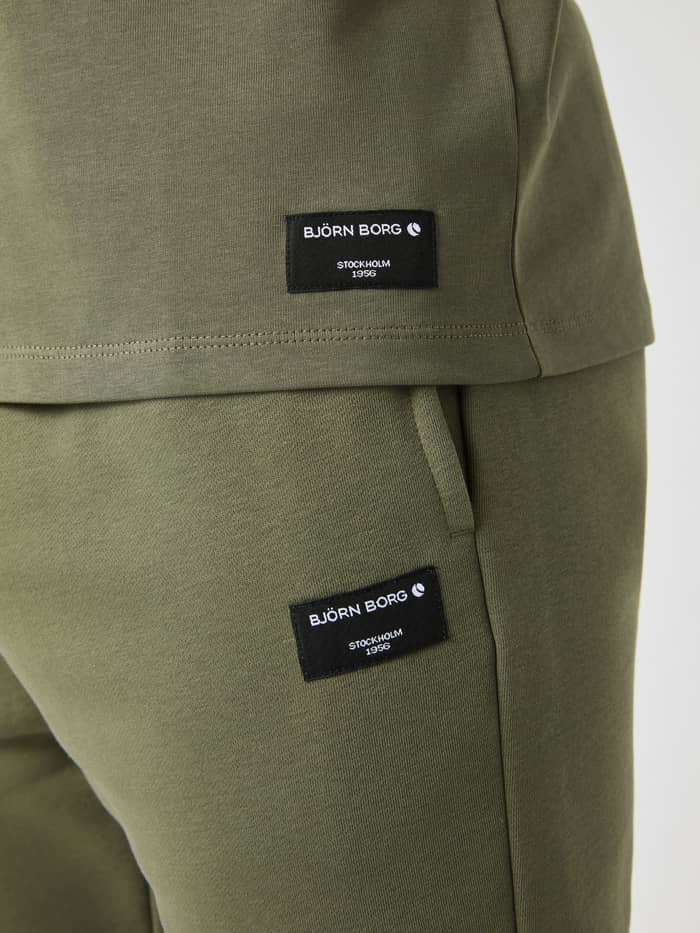 Centre High Neck T-Shirt i Dusty Olive (Grøn) set i nærbillede med sorte logomærker i blød bomuld til mænd.