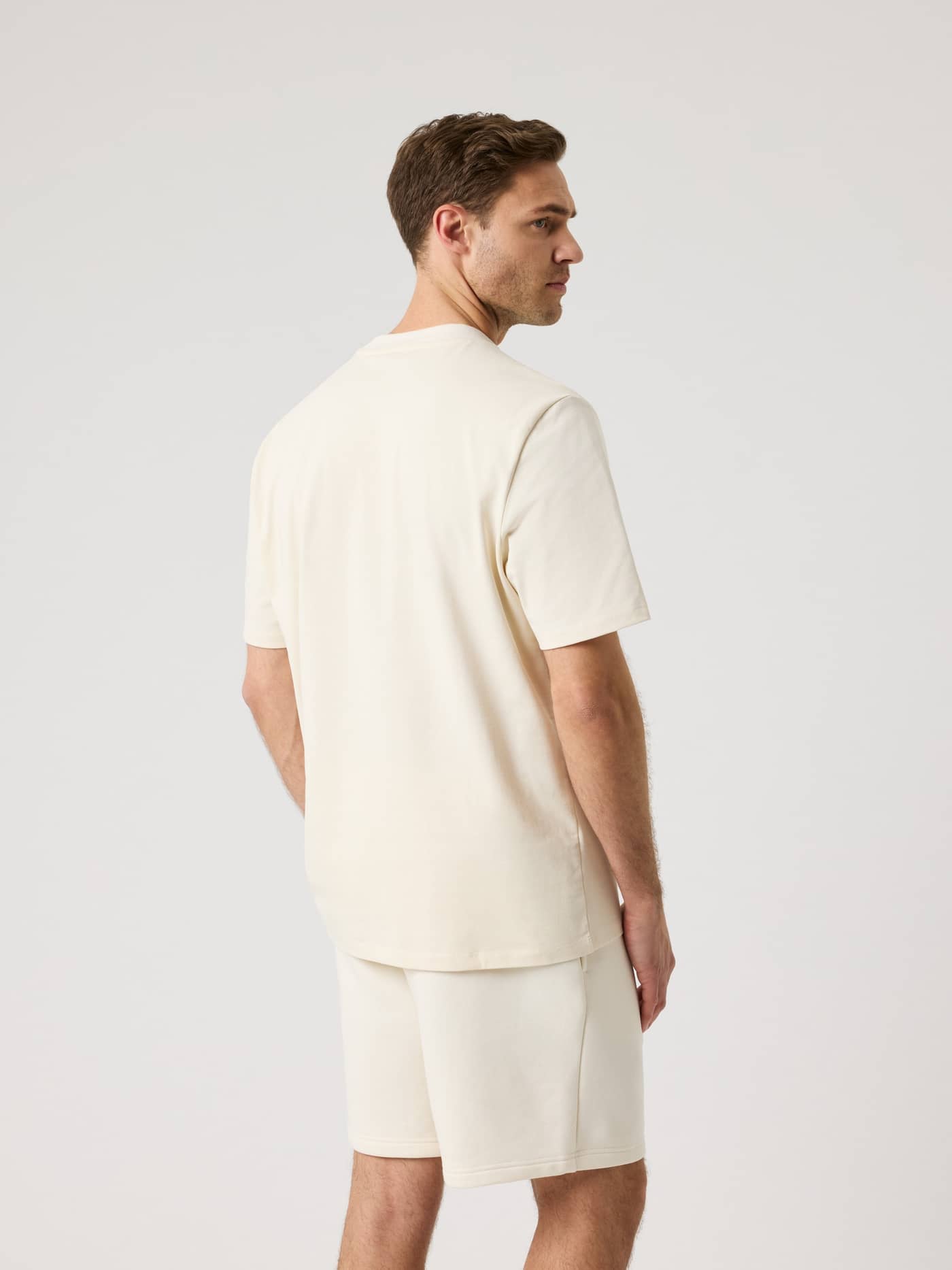 Rückansicht eines Mannes im Björn Borg Centre High Neck T-Shirt in Tofu (Weiß) mit Oversized-Passform aus 100 % Baumwolle. - Image 2