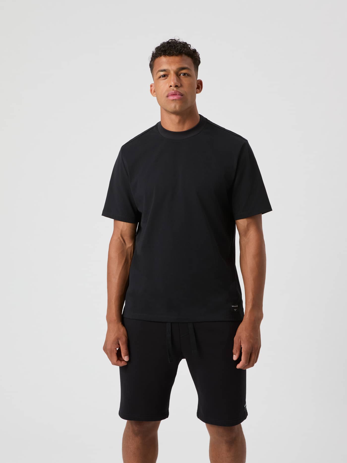 Vorderansicht eines Mannes im Björn Borg Centre High Neck T-Shirt in Black Beauty (Schwarz) mit Oversized-Passform. - Image 2