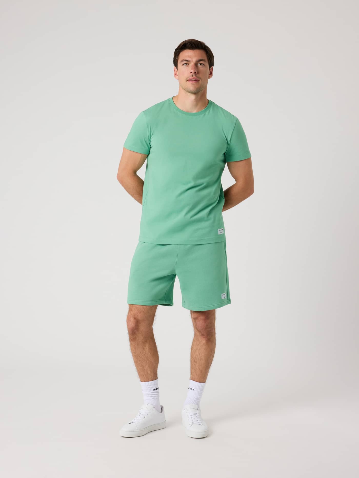 Full-body front view of a model in the Malachite Green (Green) Centre High Neck T-Shirt, featuring a stylish mock neck. - Image 3