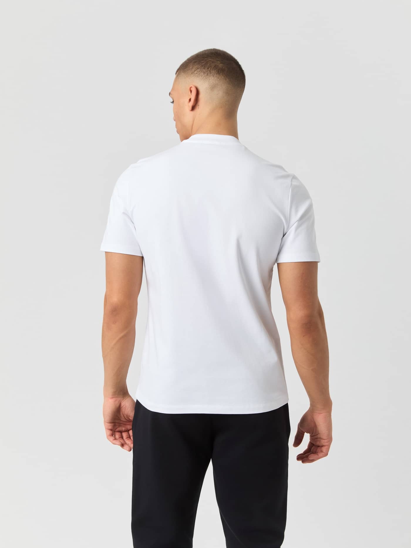 Rückansicht eines Mannes im Centre High Neck T-Shirt in Brilliant White (Weiß) aus weicher Baumwolle mit Oversized-Passform. - Image 2