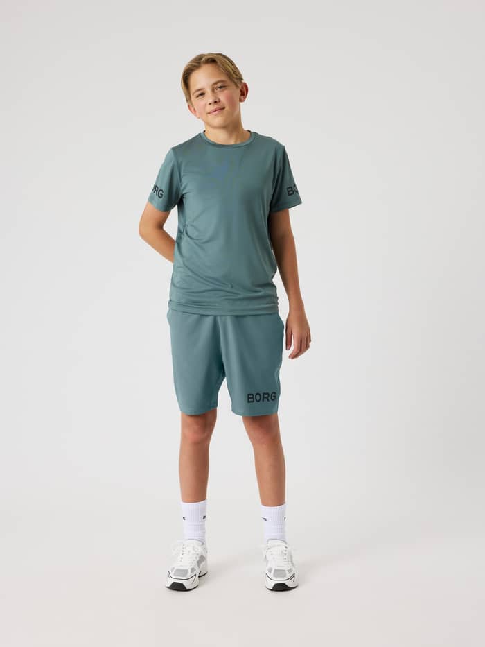 Front view of a kid wearing the Björn Borg Shorts 9 inch in Balsam Green (Green) with a black logo for training.