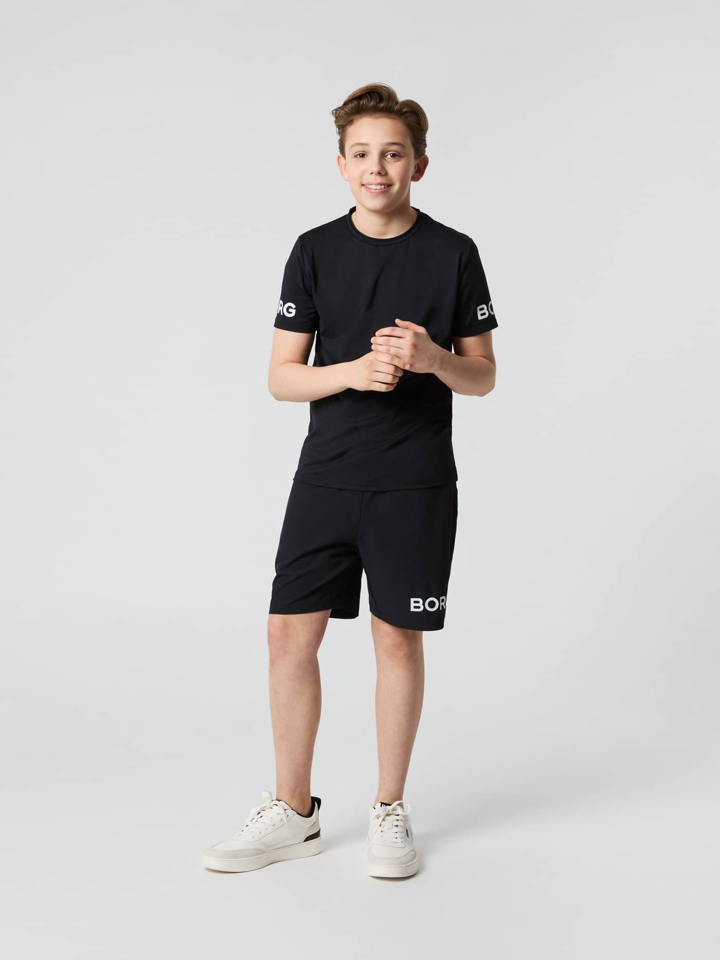 Full-body front view of a model wearing the Björn Borg Shorts in Black Beauty (Black) with a white logo for kids training. - Image 1