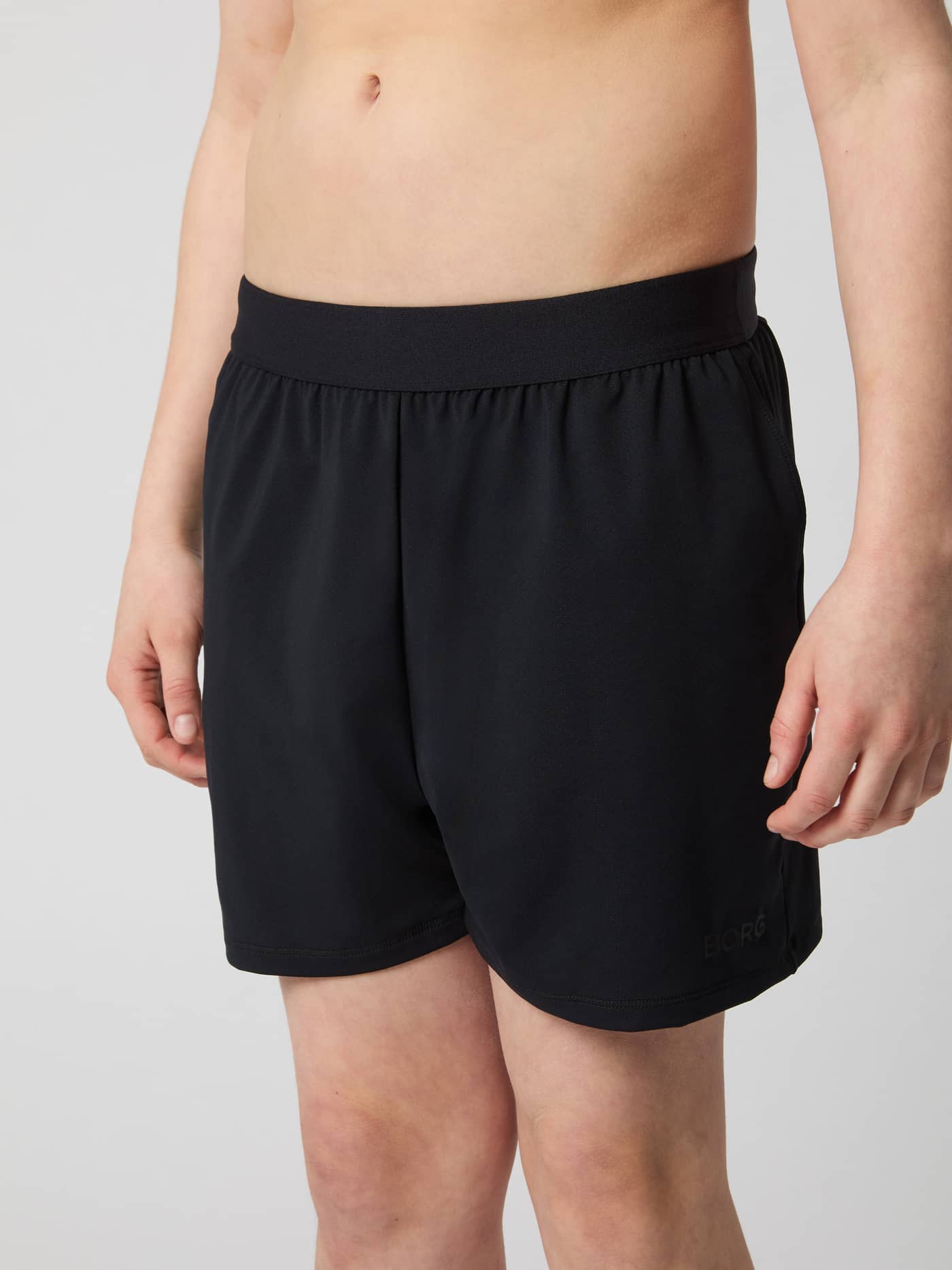 Vorderansicht der dehnbaren Borg Soft Shorts in Black Beauty (Schwarz) für Kinder mit schwarzem Logo für das Training. - Image 2