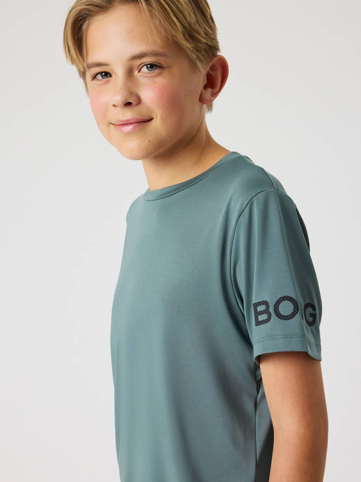 Seitenansicht des Borg T-Shirt für Kinder in Balsam Green (Grün) mit schwarzem Logo am Ärmel für das Training. - Image 4