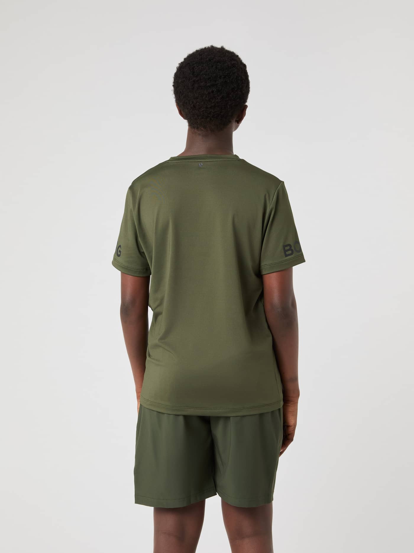 Borg T-Shirt i Forest Night (Grøn) set bagfra på et barn til træning med sorte logoer på ærmerne. - Image 2