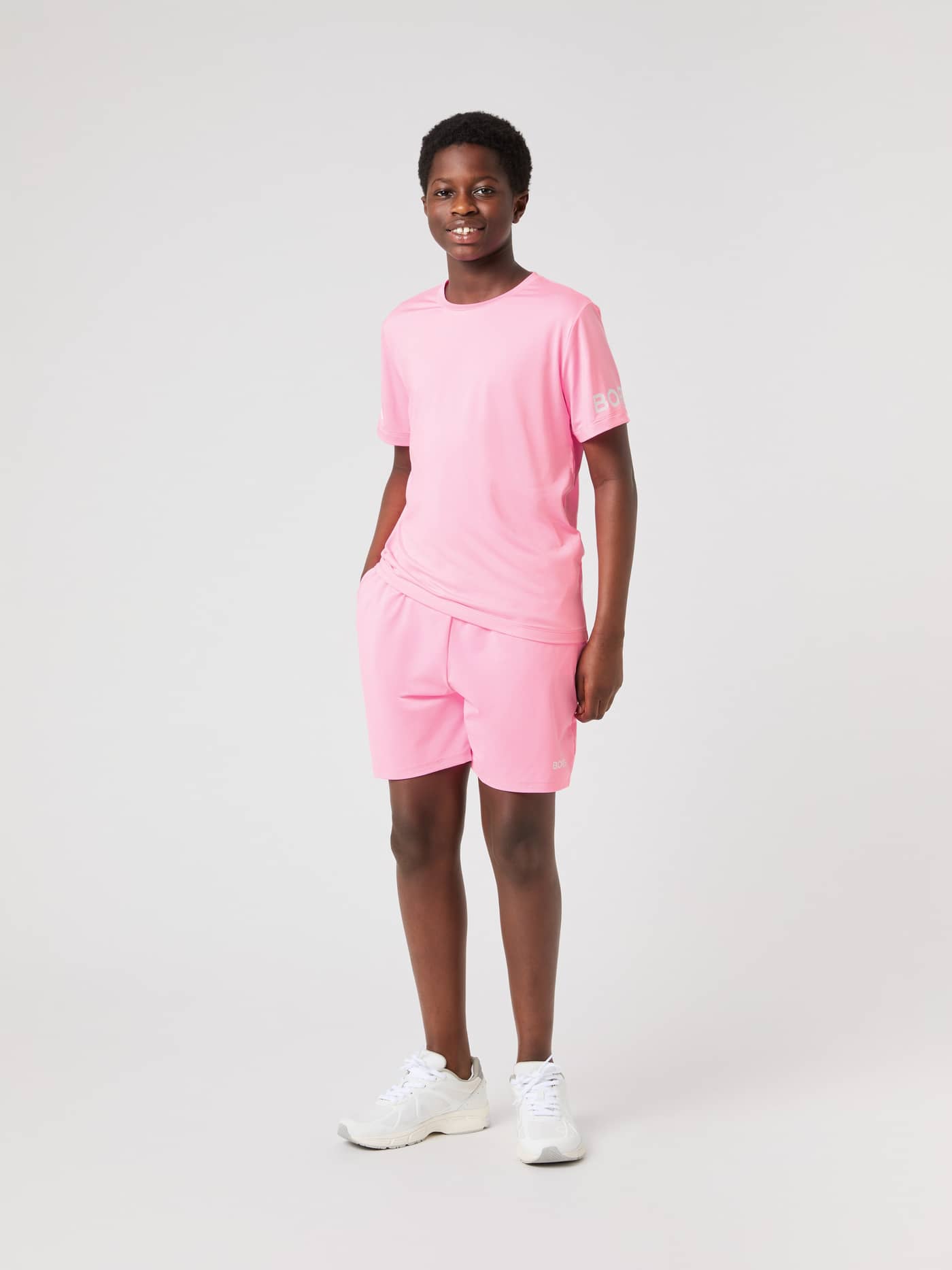 Full-body front view of a kid wearing the kids' Borg T-shirt in Cotton Candy (Pink) for training with white logos. - Image 3