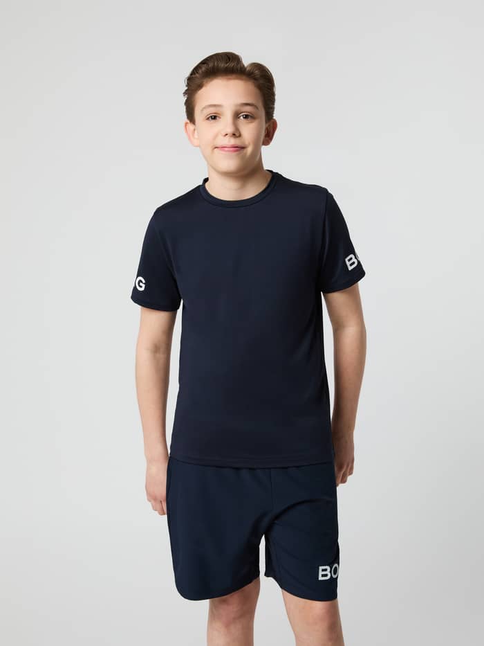 Vorderansicht eines Kindes im Borg T-Shirt in Night sky (Marineblau) für das Training mit weißen Logos an den Ärmeln. - Image 2