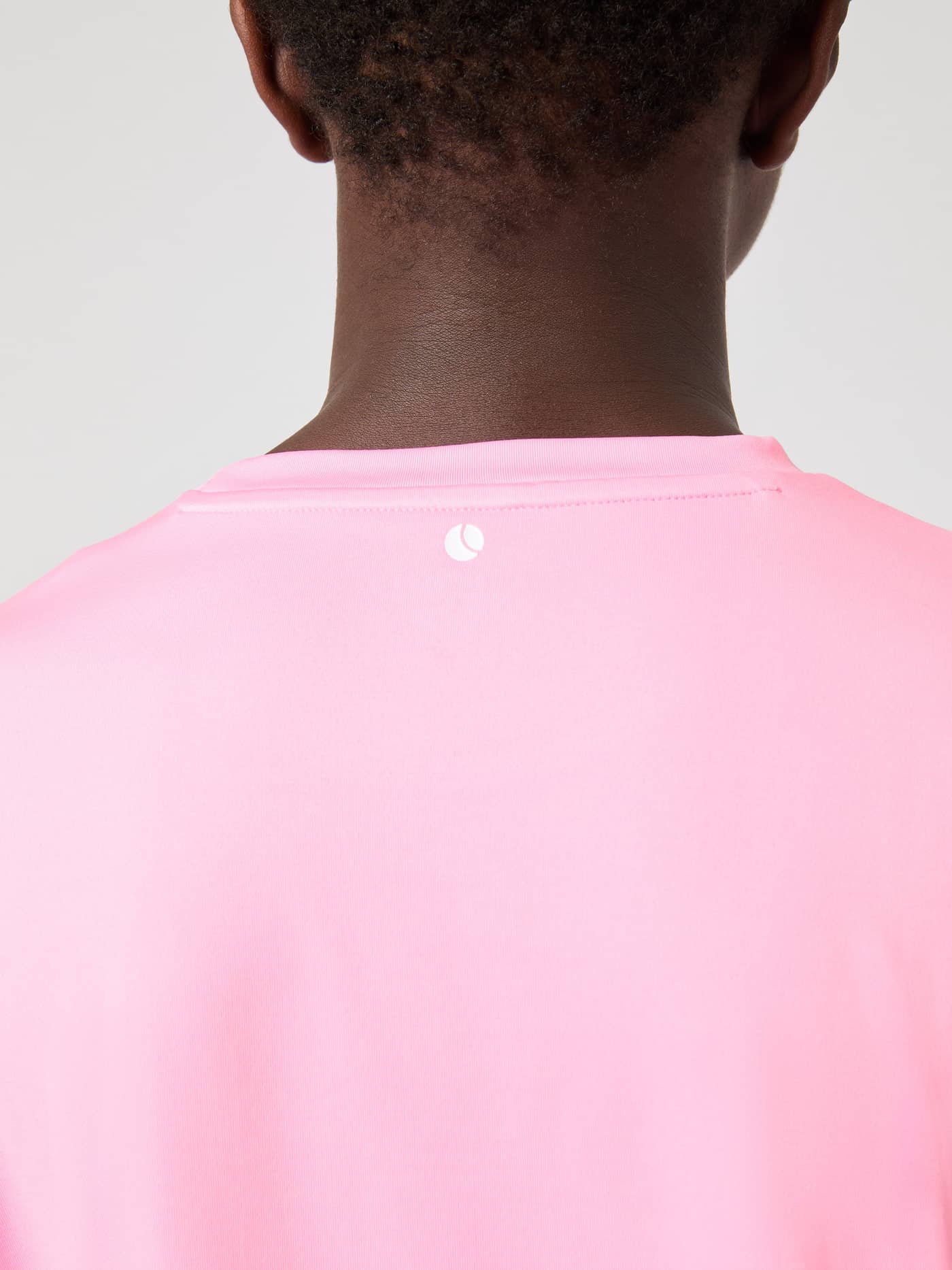 Back view of kids wearing the training Björn Borg T-Shirt in recycled Cotton Candy (Pink) with a white tennis logo. - Image 5