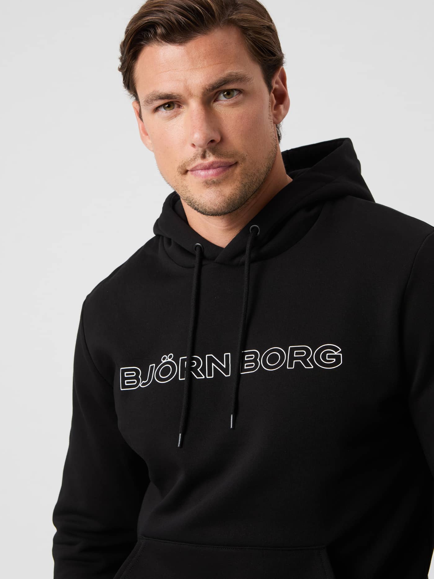 Gros plan du Borg Essential 3 Hoodie en Black Beauty (Noir) avec logo blanc, idéal pour un style décontracté. - Image 1