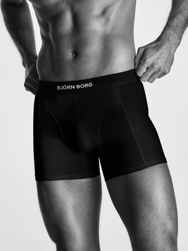 Organic Cotton Stretch Boxers 2-pack in Schwarz an einem Mann mit hochwertigem Stoff und weißem Logo-Bund.