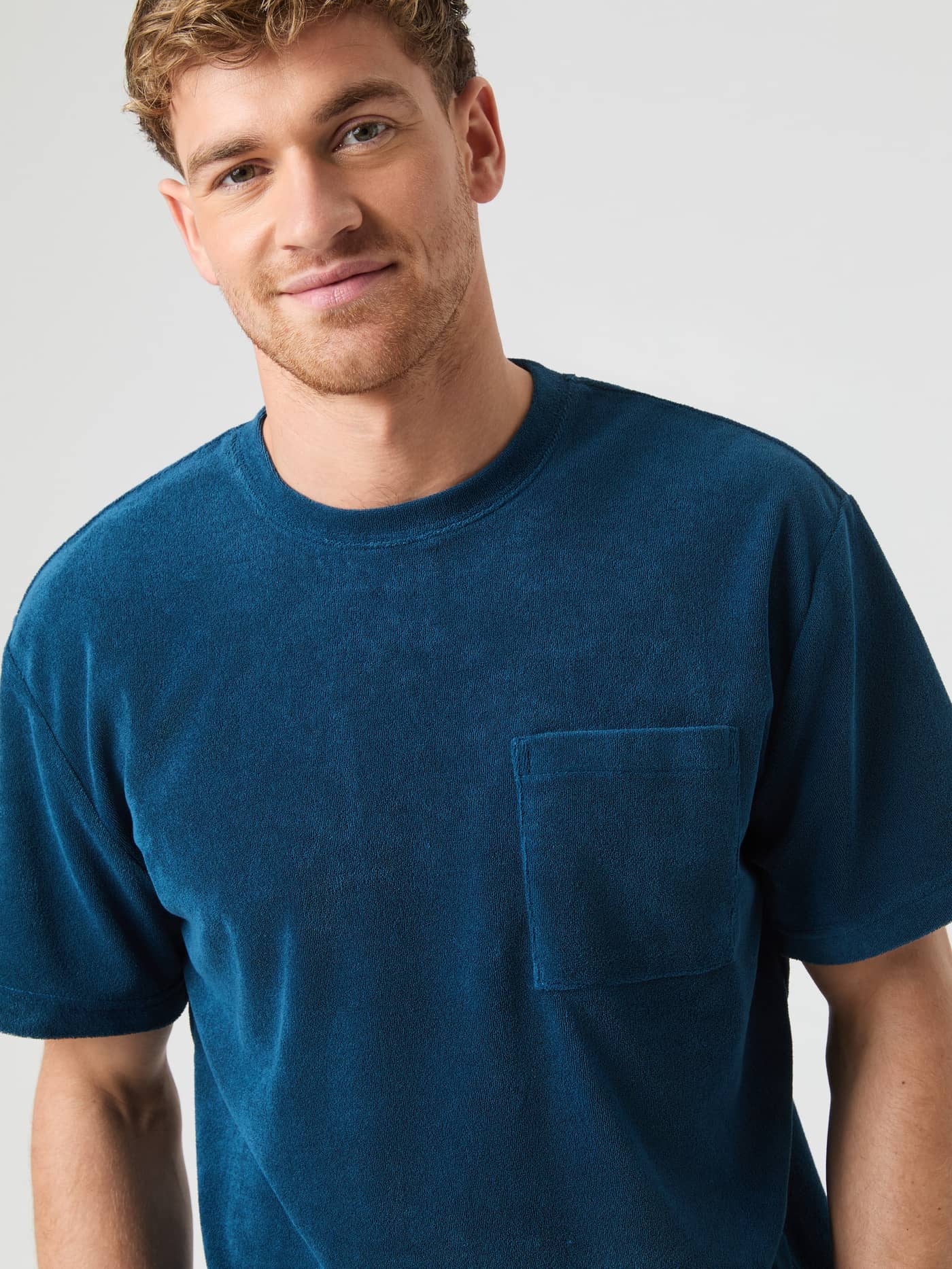 Front view of a model wearing the soft cotton Björn Borg Toweling T-Shirt in Gibraltar Sea (Blue) with a chest pocket. - Image 1