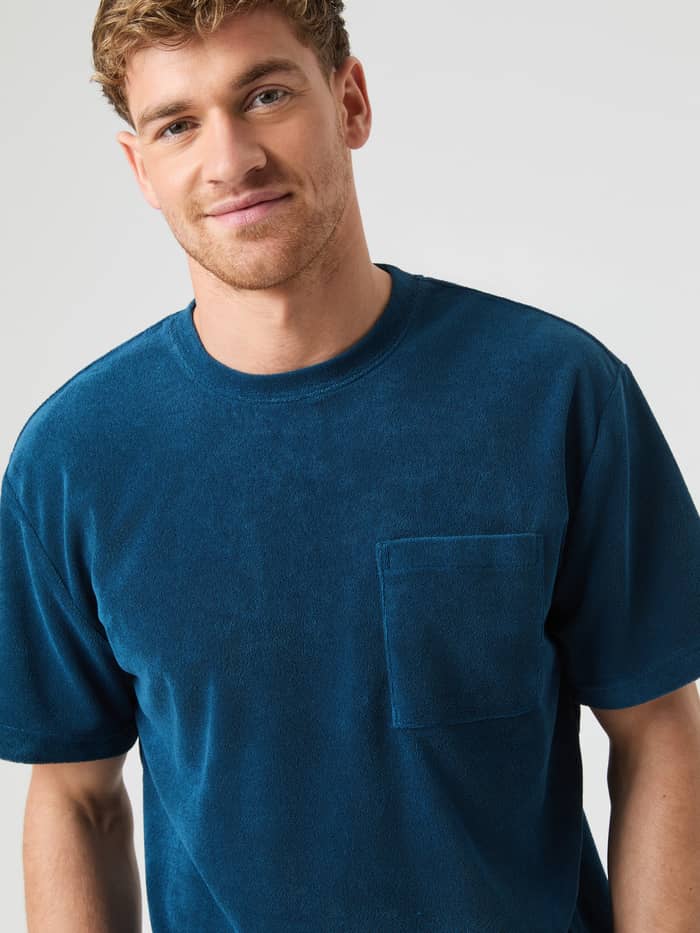 Front view of a model wearing the soft cotton Björn Borg Toweling T-Shirt in Gibraltar Sea (Blue) with a chest pocket.