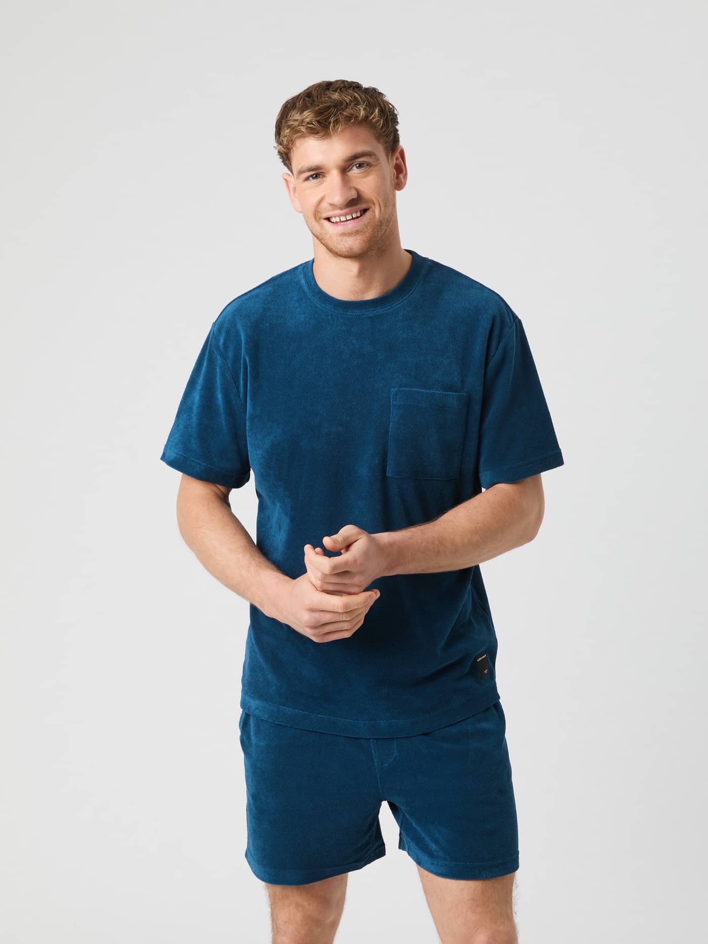 Front view of a man wearing the soft cotton Borg Toweling T-Shirt in Gibraltar Sea (Blue) with a relaxed fit and black logo. - Image 5