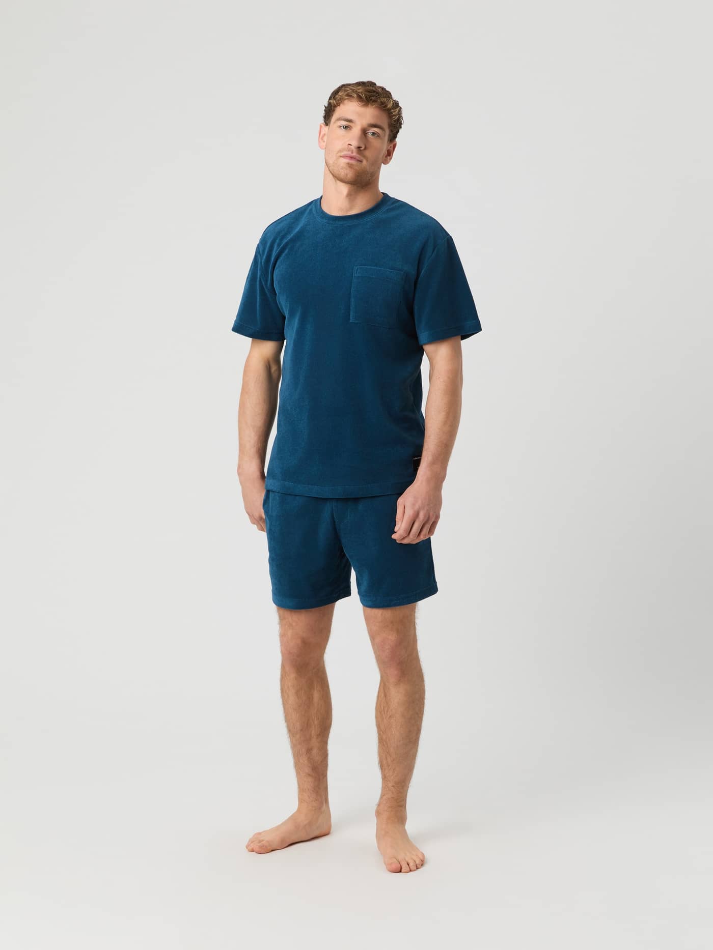 Full-body front view of a man wearing the oversized Borg Toweling T-Shirt in Gibraltar Sea (Blue) featuring a chest pocket. - Image 3