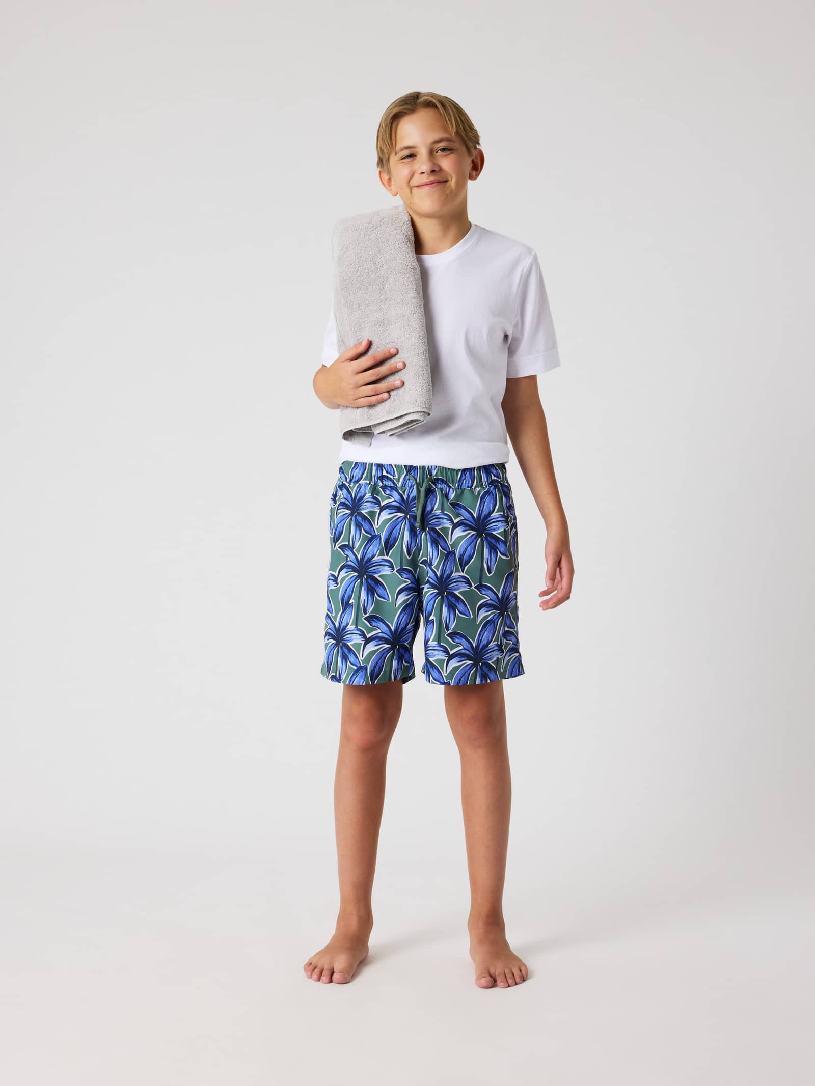 Borg Print Swim Shorts voor kids in Palms On Palms 1 (Blauw/Groen) met palmenprint in een volledig vooraanzicht. - Image 1