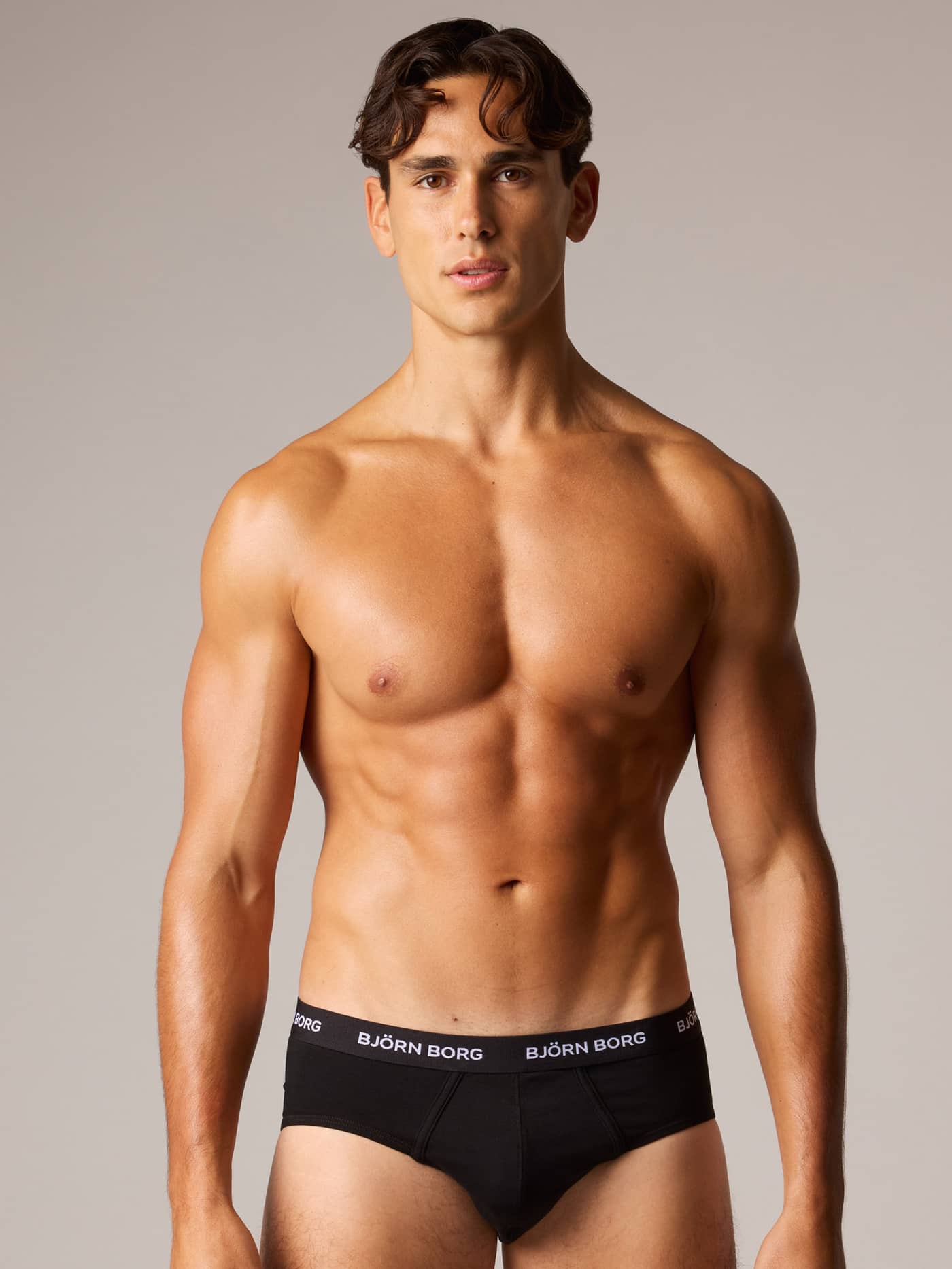 Front view of a man wearing Cotton Stretch Briefs 3-pack in Black (Black) with white Björn Borg logo for style and function. - Image 1