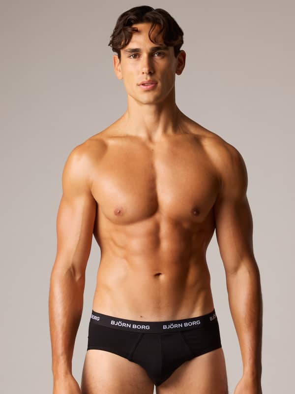 Cotton Stretch Briefs 3-pack i svart på en man sedd framifrån med vit Björn Borg-logotyp för stil och funktion.