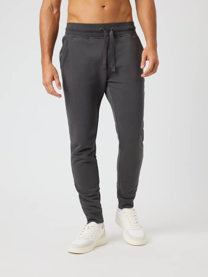 Front view of a man wearing Centre Tapered Sweatpants in Asphalt (Grey) featuring a slim fit and drawstring waist.