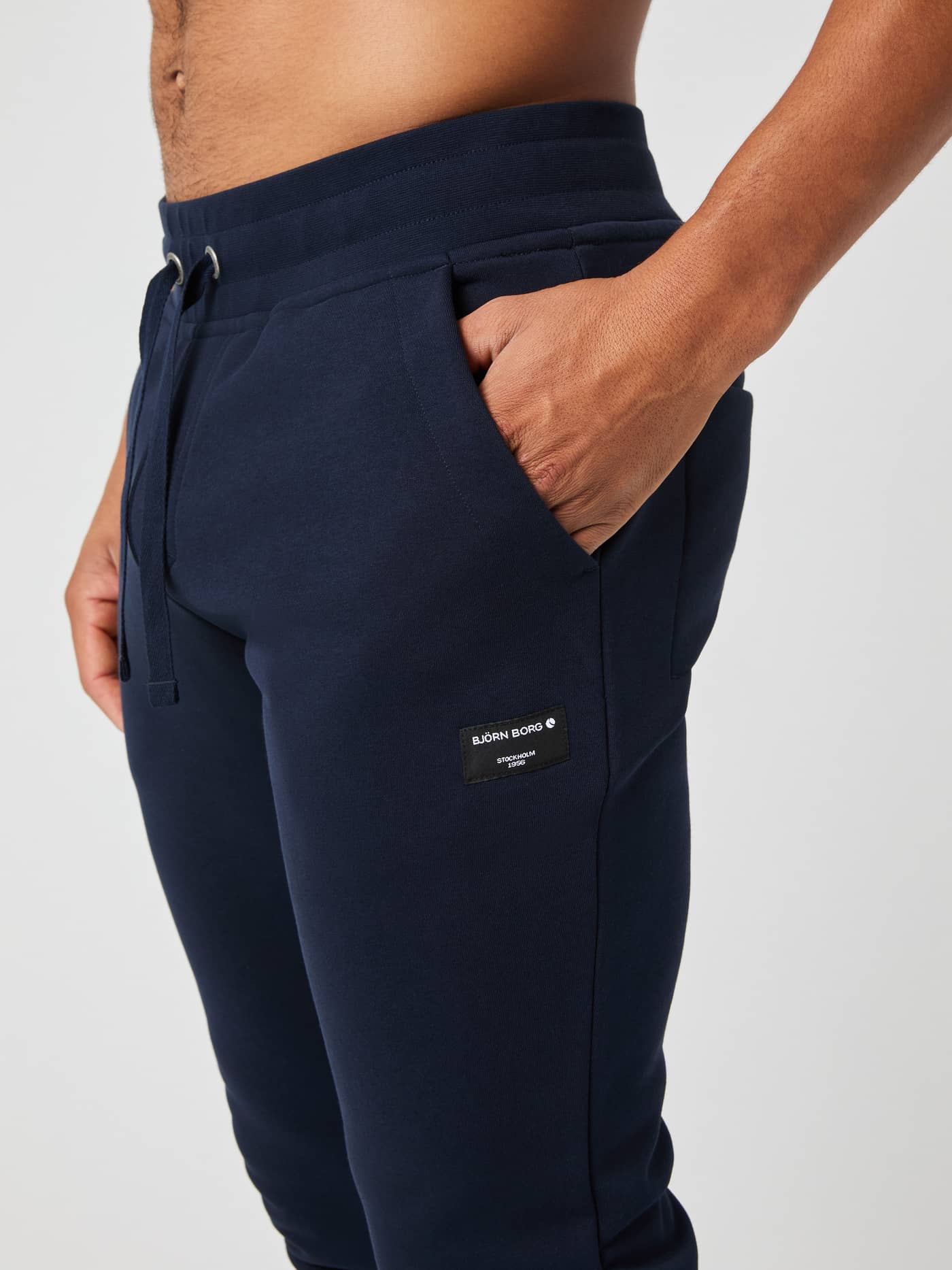Close-up of the navy Björn Borg Centre Tapered Sweatpants, detailing the side pocket, drawstring waist, and logo patch. - Image 3