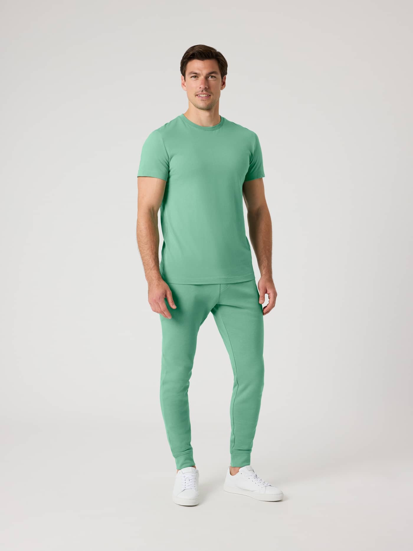 Vooraanzicht van een man in de Björn Borg Centre Tapered Sweatpants in Malachite Green (Groen) met een bijpassende top. - Image 3