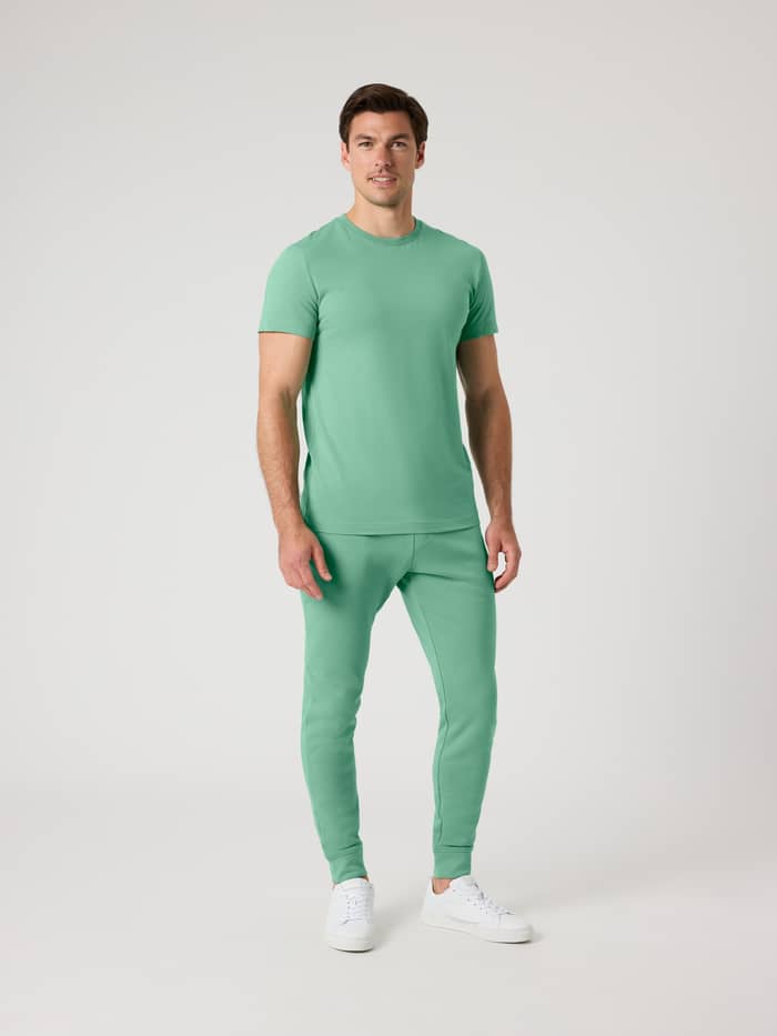 Vooraanzicht van een man in de Björn Borg Centre Tapered Sweatpants in Malachite Green (Groen) met een bijpassende top. - Image 3
