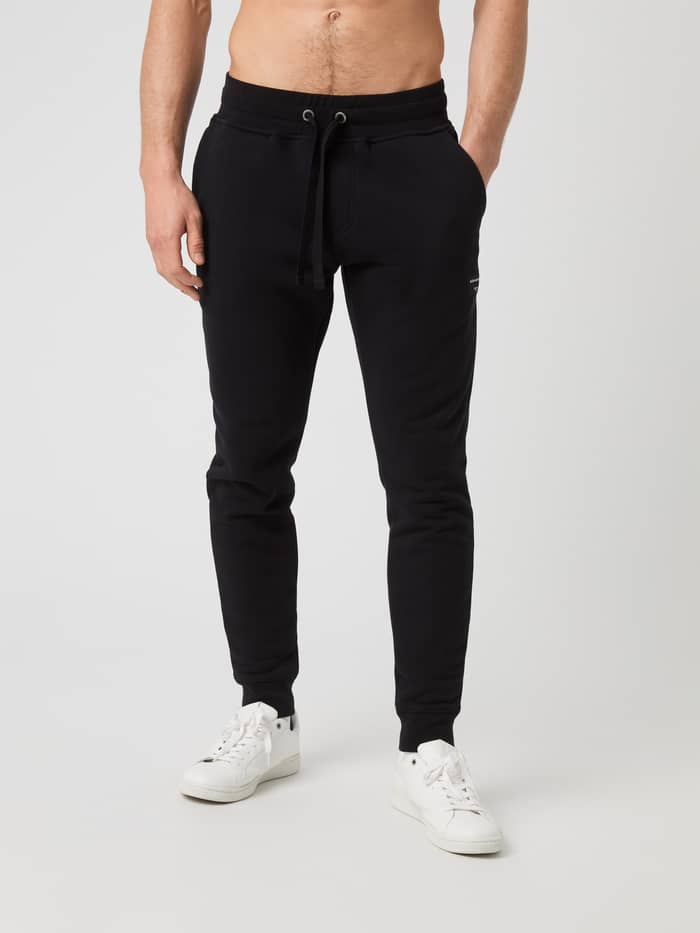 Vorderansicht eines Mannes in der Centre Tapered Sweatpants in Black Beauty (Schwarz) mit stilvollem Fit und Funktion.