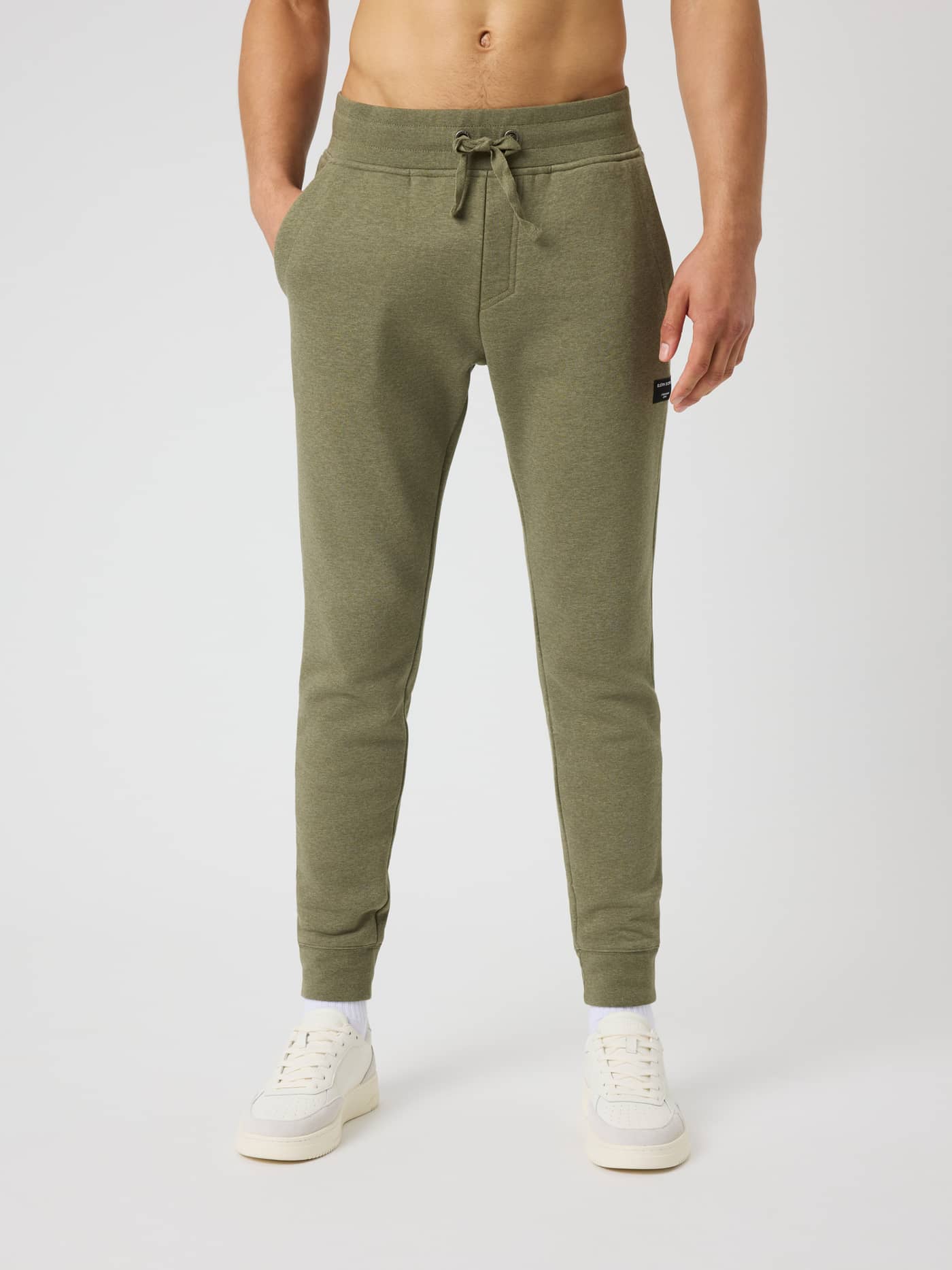 Vue de face d'un modèle en Centre Tapered Sweatpants en Winter Moss Melange (Vert) à coupe ajustée avec un logo noir. - Image 1