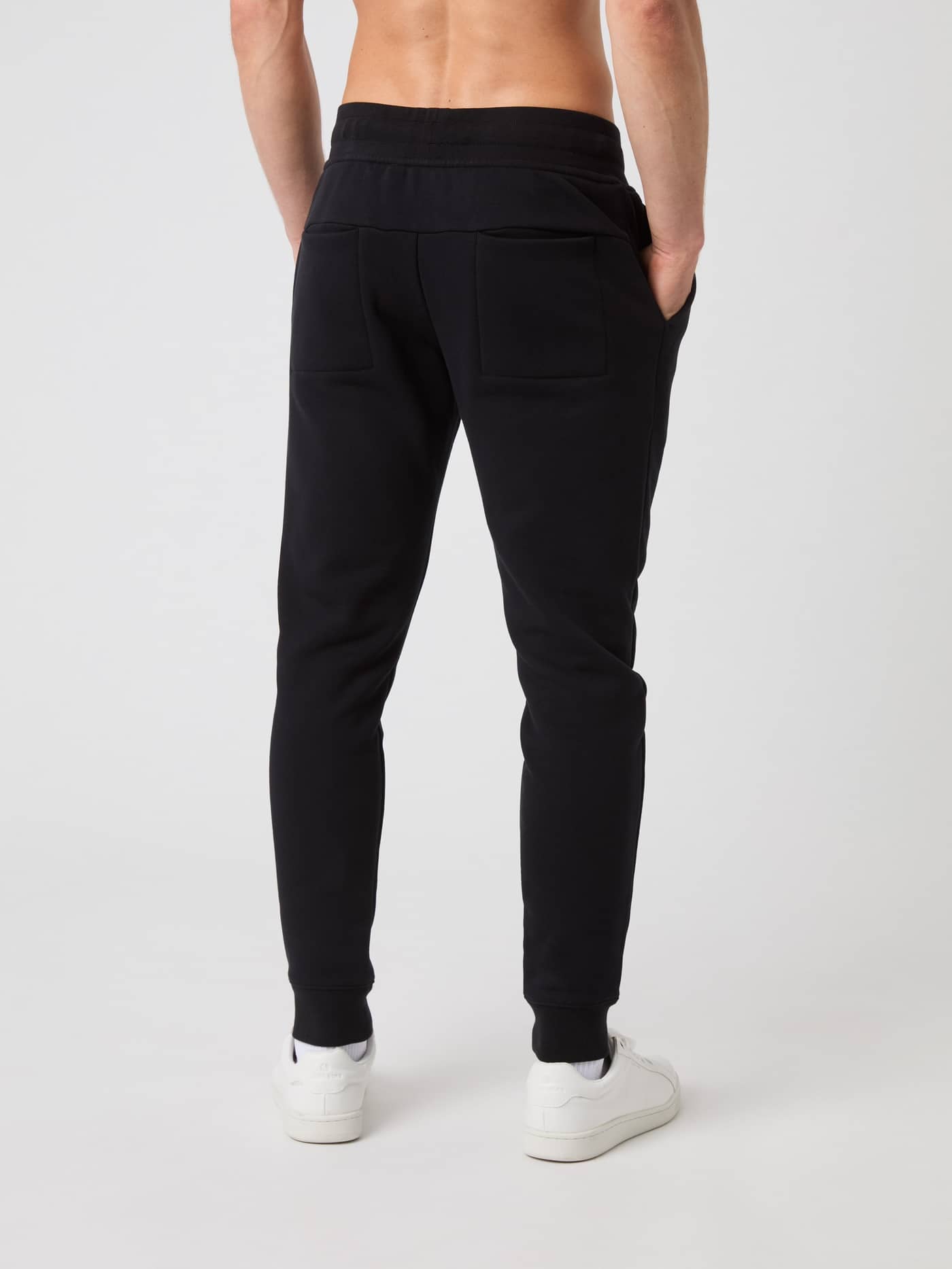 Back view of a model in black Björn Borg Centre Tapered Sweatpants, showing the two back pockets and slim, tapered fit. - Image 2