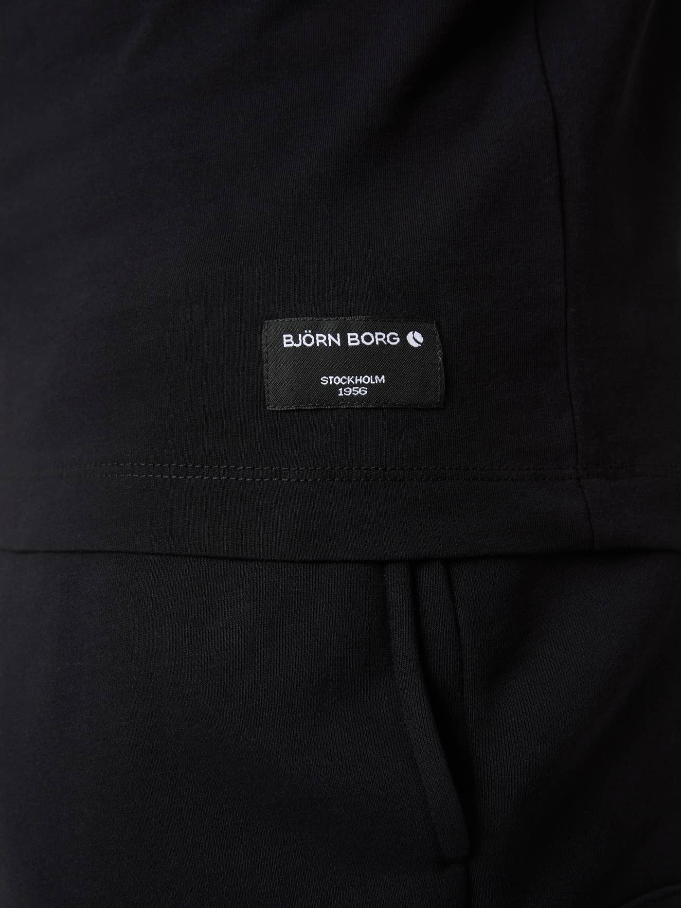Close-up van het geweven Björn Borg Stockholm 1956-label op de zoom van het Centre T-Shirt in Black Beauty (Zwart). - Image 5
