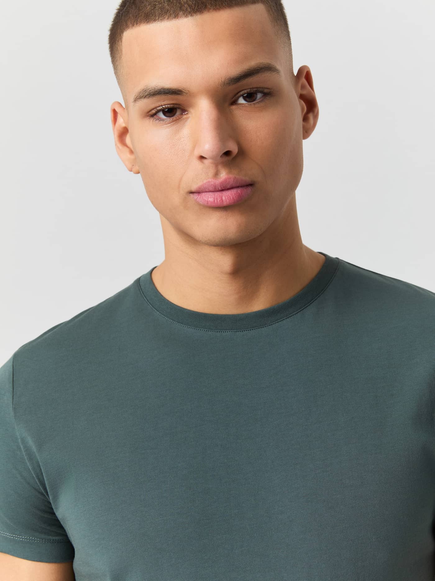 Close-up of a male model wearing the green Björn Borg Centre T-shirt, showing the round neck. - Image 4