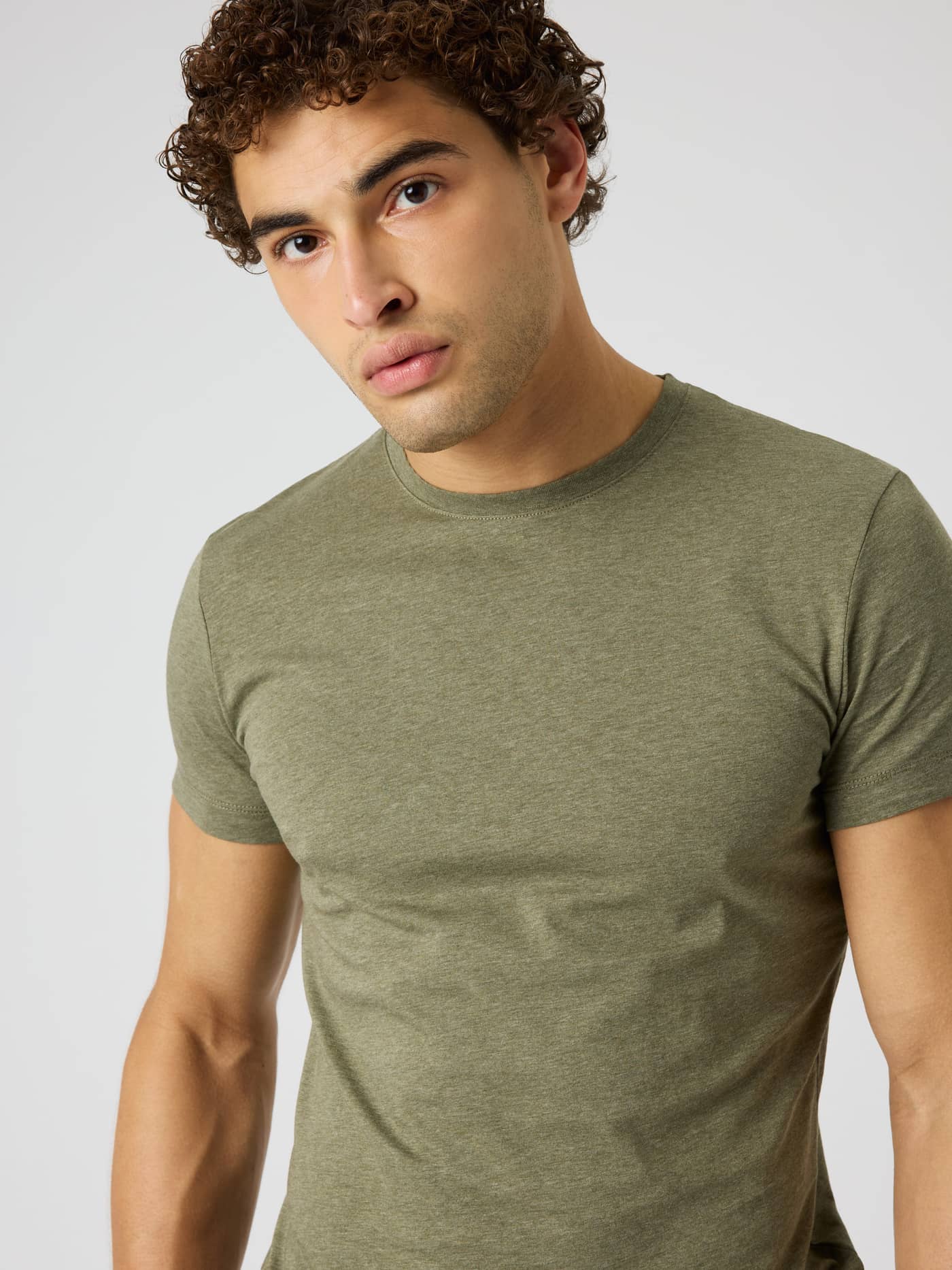 Close-up of a man wearing the Björn Borg Centre T-Shirt in Winter Moss Melange (Green) with a soft melange texture. - Image 4