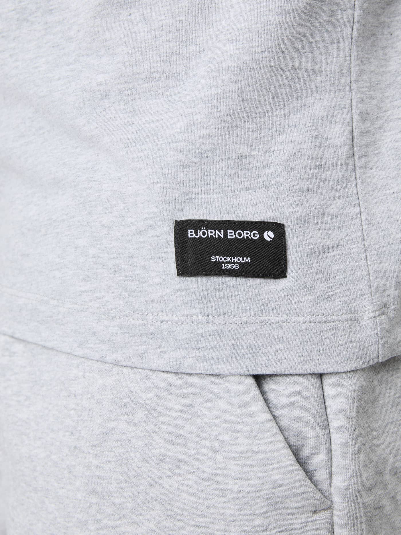 Gros plan du Centre T-Shirt en Light Grey Melange (Gris) avec son étiquette tissée noire pour un style décontracté. - Image 4