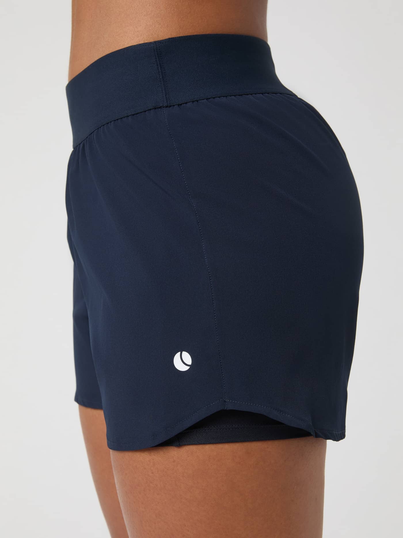 Side view of a model wearing the Björn Borg Ace 2 in 1 Shorts in navy, showing the fit and layered design. - Image 5