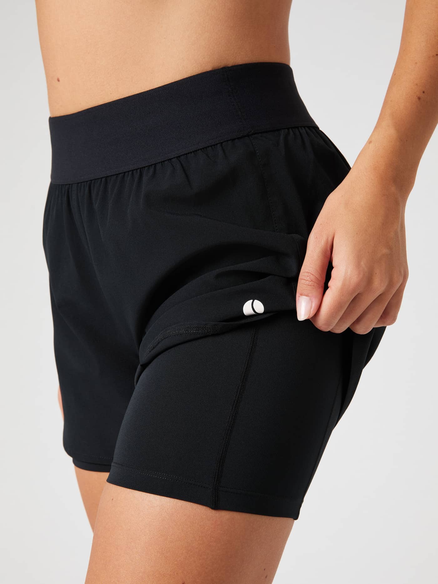 Detailed side view of the black Björn Borg Ace 2-in-1 Shorts, showing the inner shorts and the tennis ball pocket. - Image 4