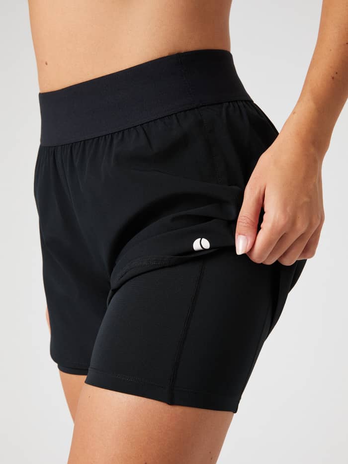 Detailed side view of the black Björn Borg Ace 2-in-1 Shorts, showing the inner shorts and the tennis ball pocket. - Image 4