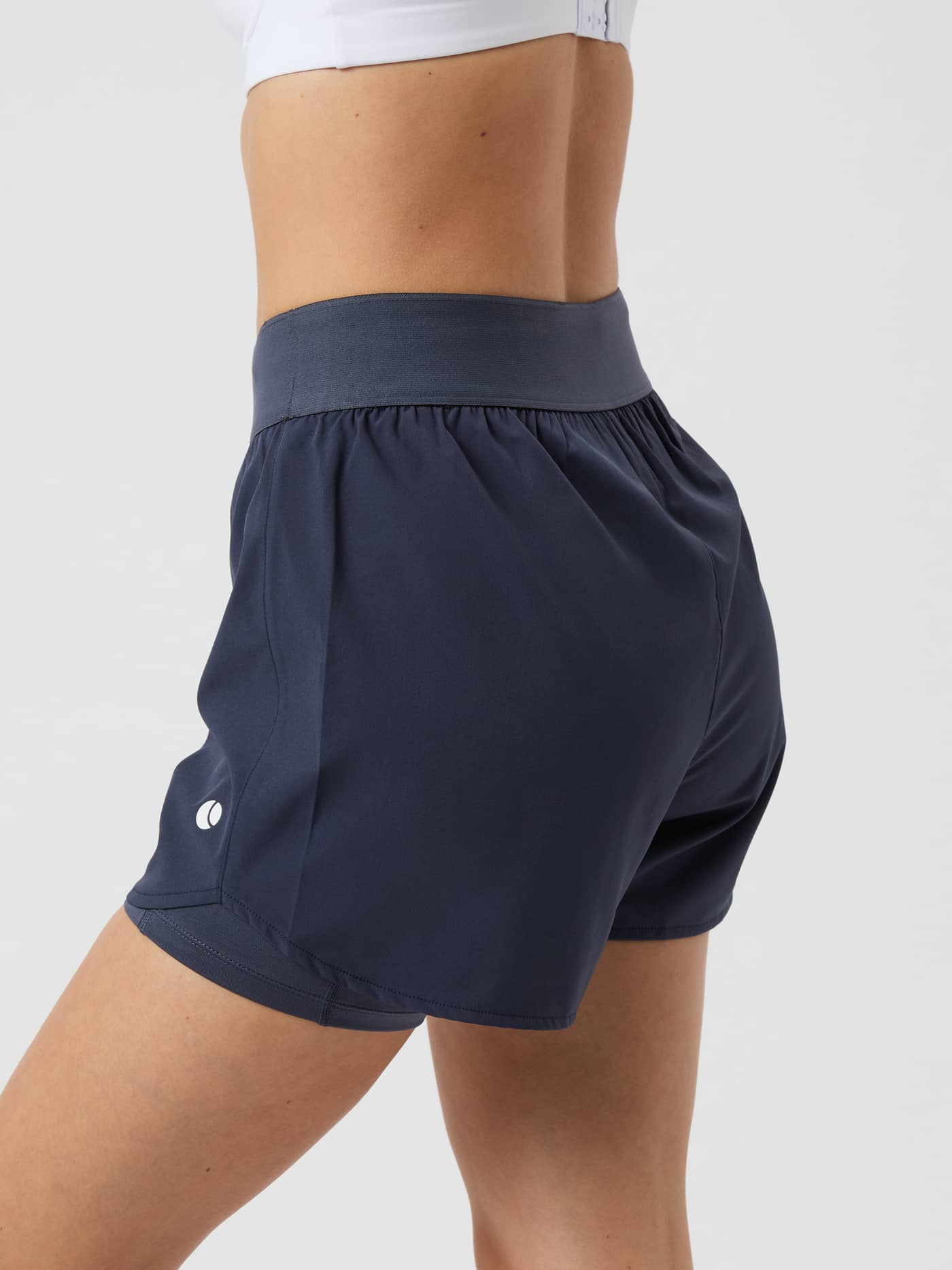 Side and back view of a woman wearing the Björn Borg Ace 2 in 1 Shorts in Odyssey Gray. - Image 2