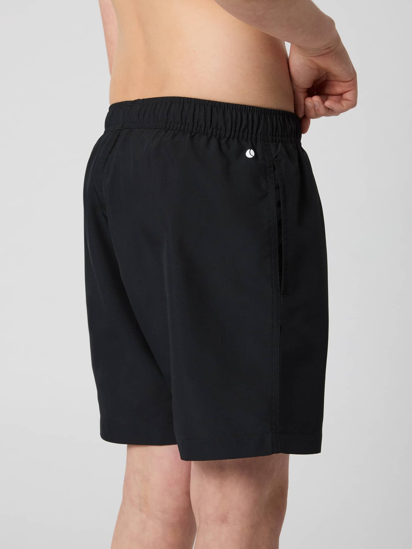 Vue de profil d'un enfant portant le Borg Swim Shorts en Black Beauty (Noir) avec un petit logo. - Image 3