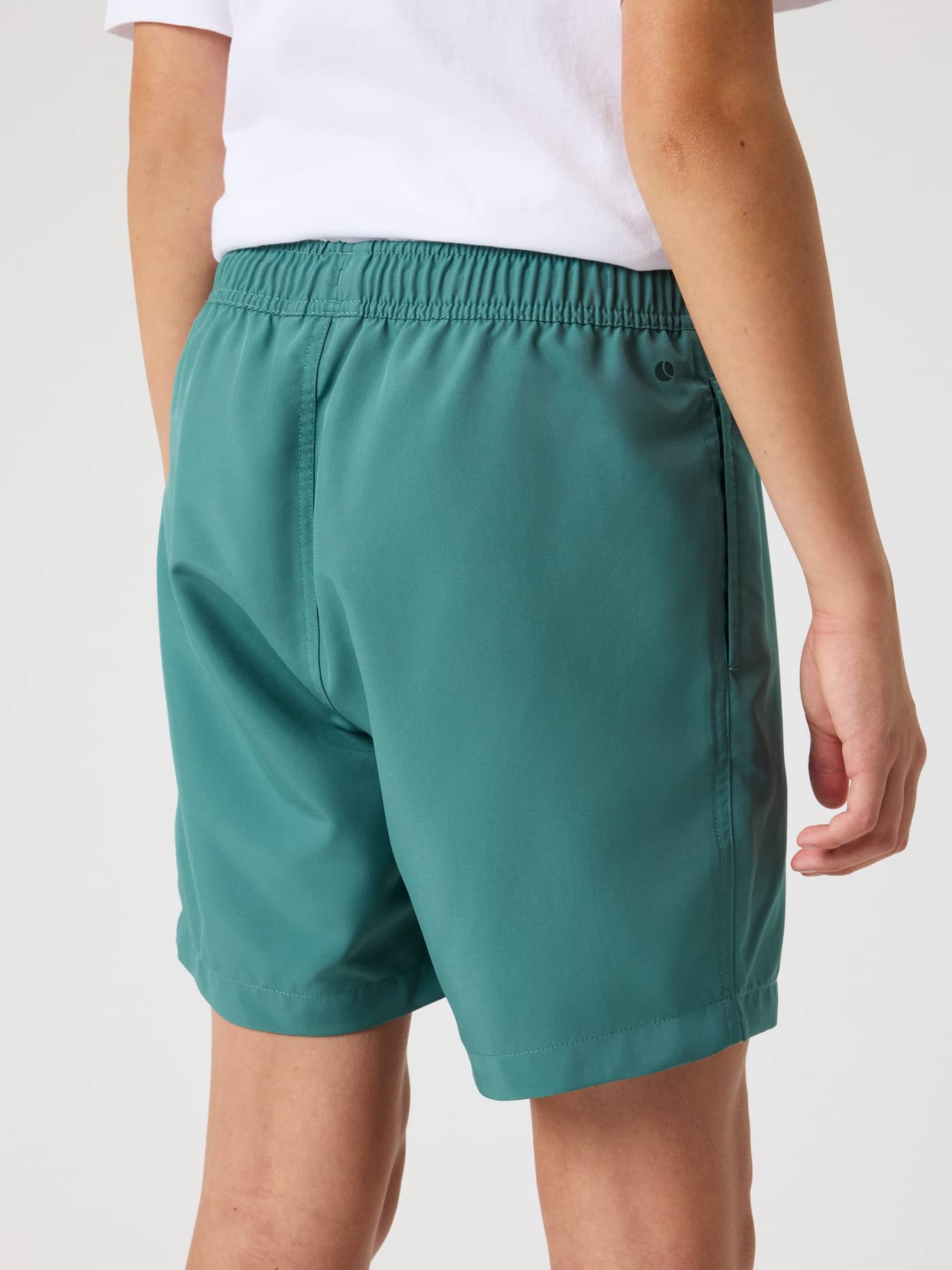 Back view of a kid wearing functional Borg Swim Shorts in Blue Spruce (Green) with an adjustable elastic waist. - Image 2