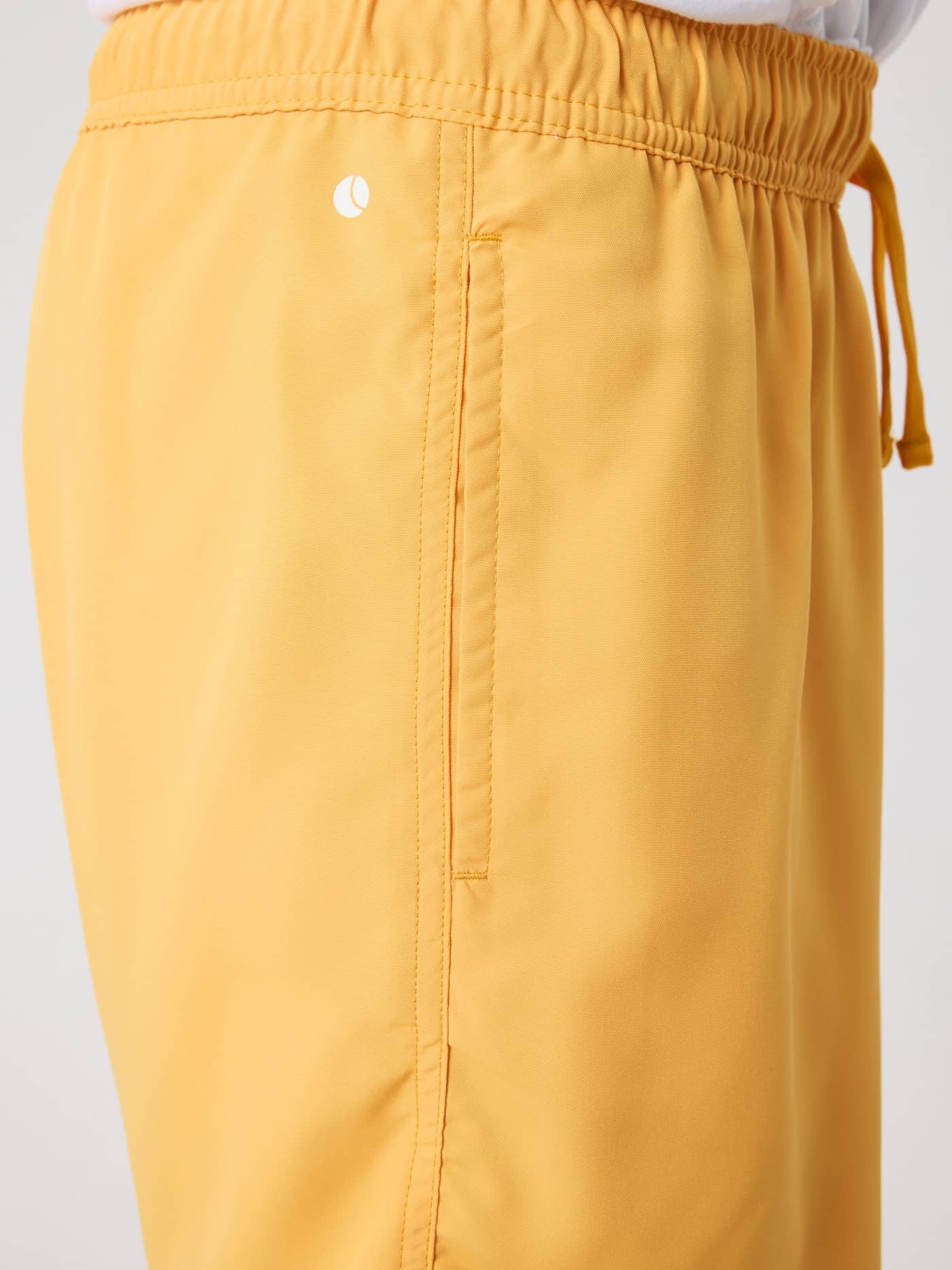 Borg Swim Shorts til børn i Marigold (Gul) med sidelomme og lille hvidt logo, set tæt på fra siden. - Image 4