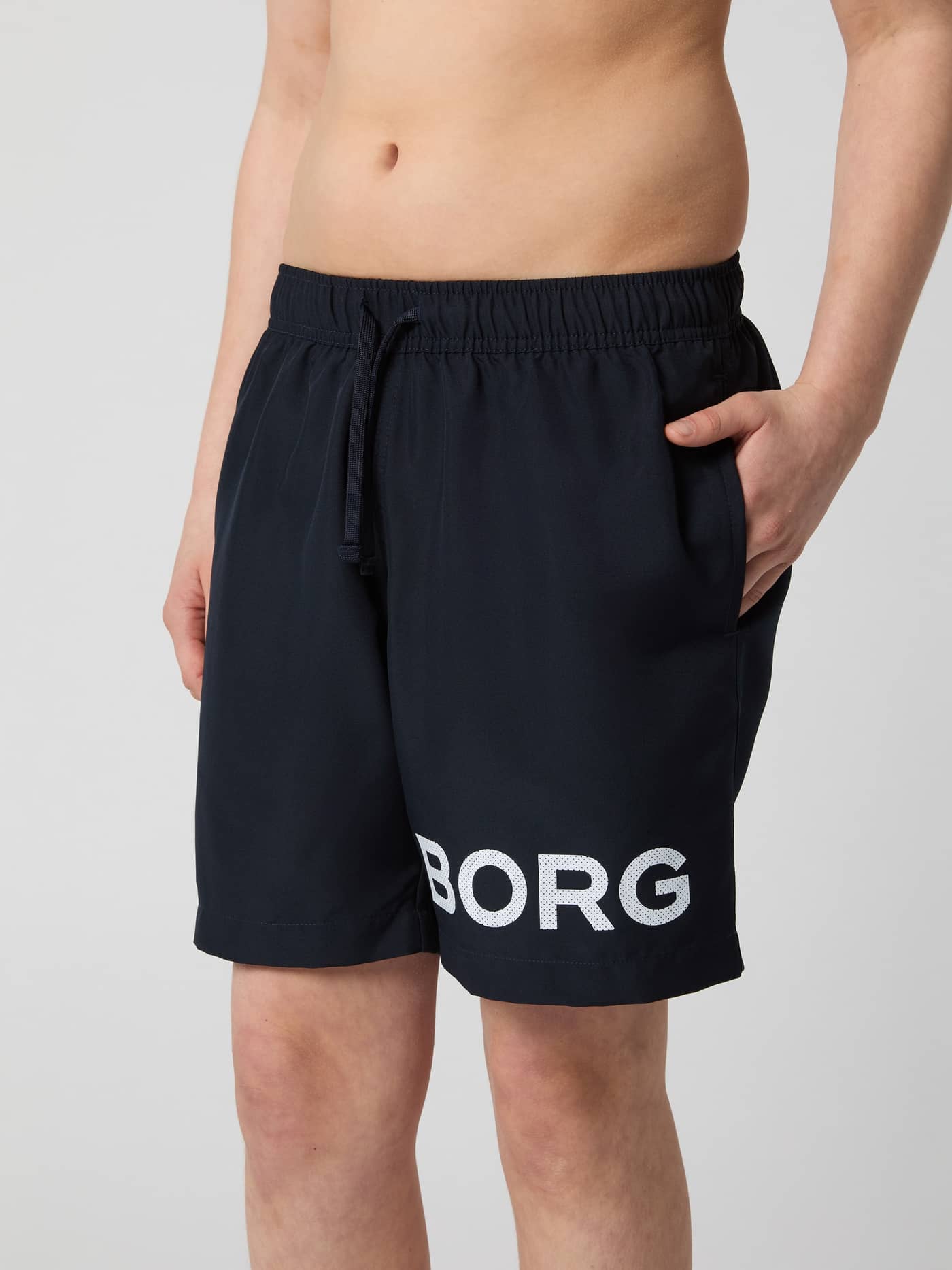 Borg Swim Shorts til børn i Night sky (Marineblå) med et hvidt logo på benet set forfra. - Image 1