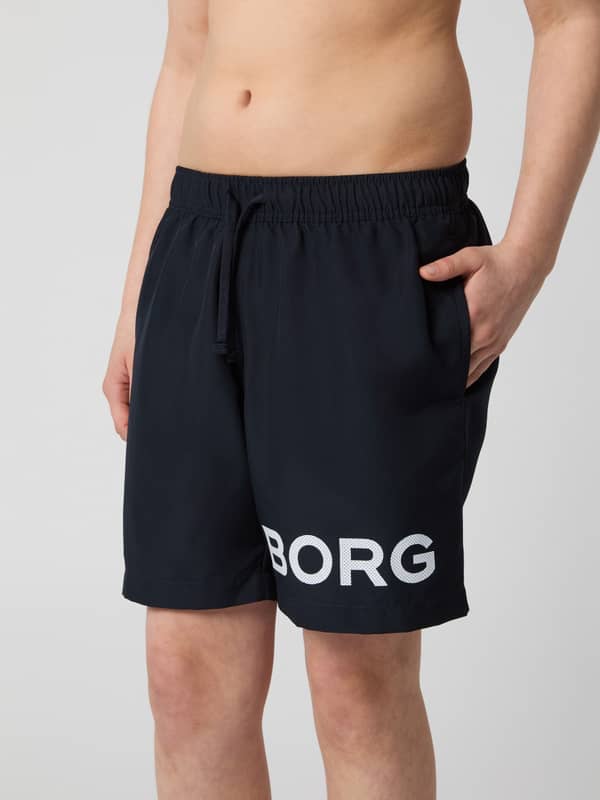 Borg Swim Shorts til børn i Night sky (Marineblå) med et hvidt logo på benet set forfra.
