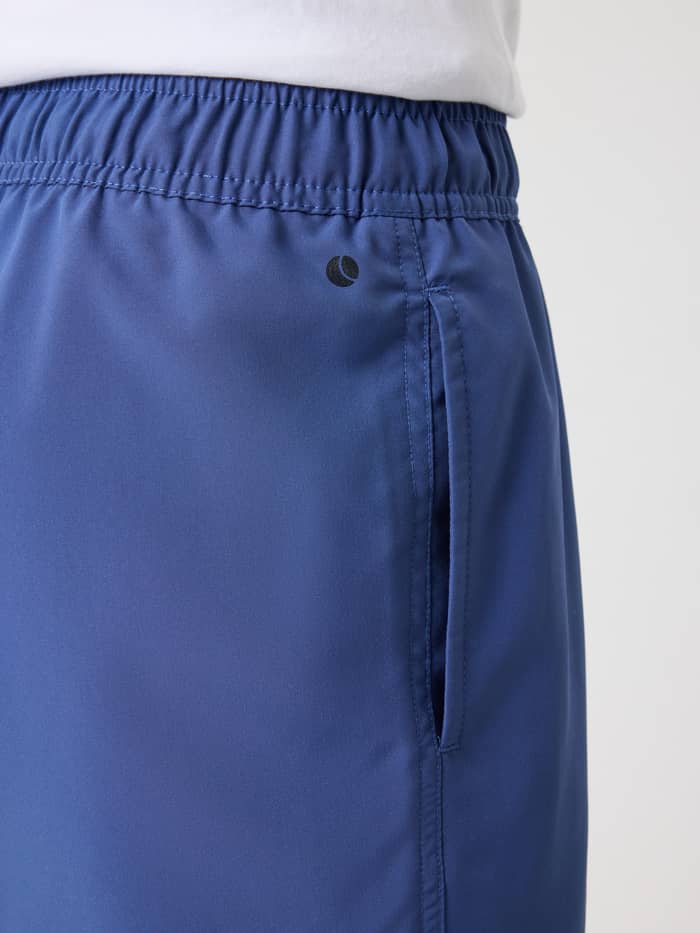 Borg Swim Shorts til børn i Coastal Fjord (Blå) vist i nærbillede med sidelomme og sort logo. - Image 4
