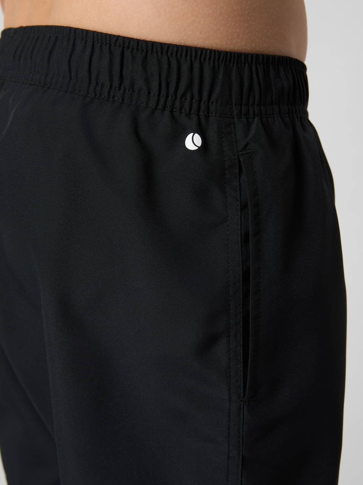 Gros plan détaillé du Borg Swim Shorts pour enfants en Black Beauty (Noir) montrant la poche latérale et le logo blanc. - Image 4